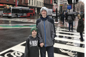 Aidan stands on the streets in Chinatown with his brother, Ryker.