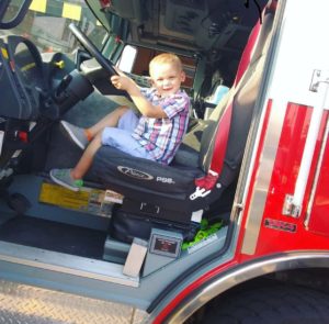 Carter poses in the driver's seat of a firetruck.