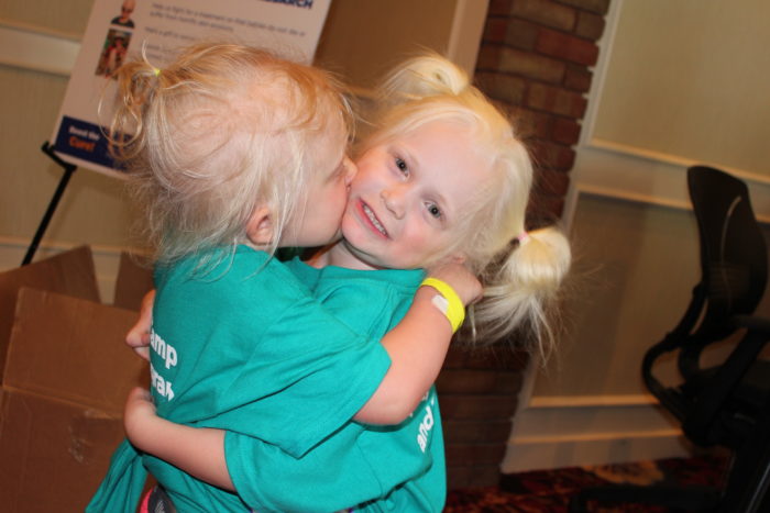 Two girls affected by ectodermal dysplasias are hugging.
