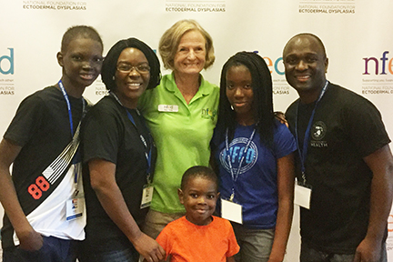 Mary Fete stands with a family affected by ectodermal dysplasia at the Family Conference.