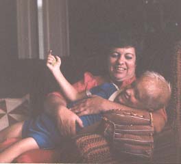 NFED founder Mary Kaye Richter is sitting in a chair. Her young son is laying in her arms. 
