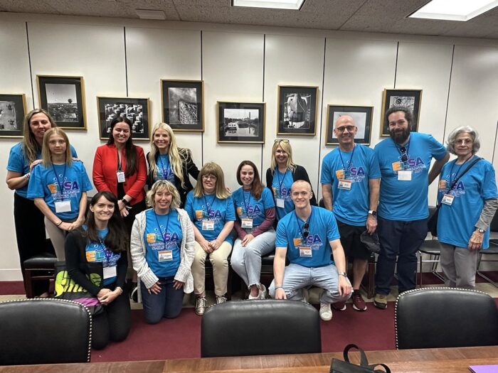 Ten ELSA advocates are posed with a staffer in a Congressional office.