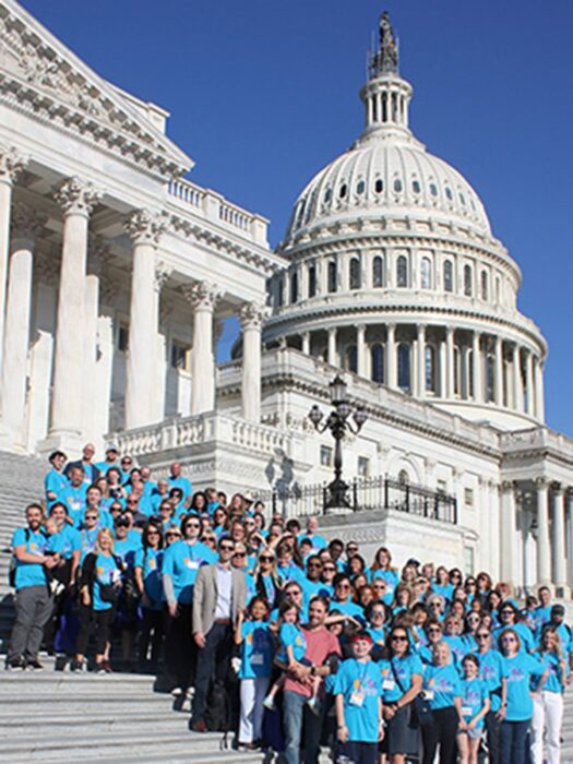 NFED advocates stand on the steps of the U.S. Capitol Building. All are wearing matching blue shirts.