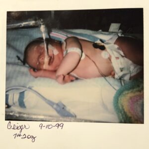 Greta as a baby in the hospital with life saving monitoring devices connected to her body.