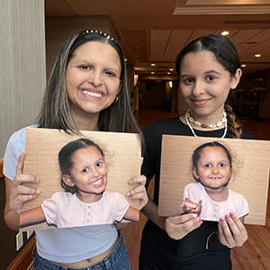 Alicia and Luna hold photos of themselves when they were 6 years old.