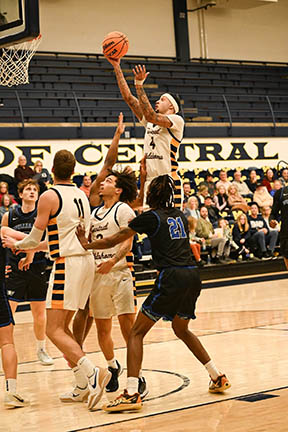 Jacobi shoots in a game while players and crowd watch.