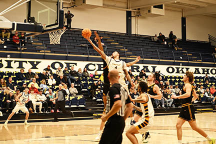Jacobi shoots in a game while players and crowd watch.