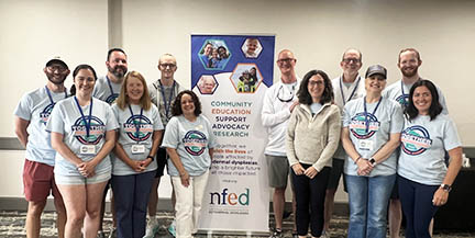 The members of the Family Conference Committee post with a vertical NFED banner.