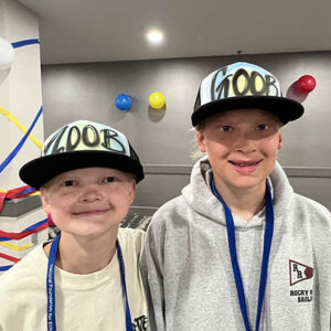 Two boys are wearing baseball hats that say Zoob and Goob
