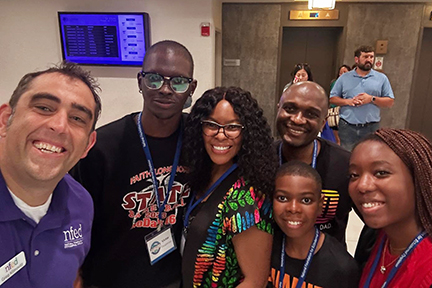 Greg poses for a selfie with a family attending the Conference.