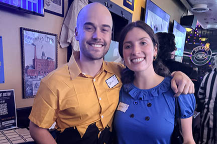 A man is dressed up as Charley Brown and a woman is dressed up as Lucy from the Peanuts comic strip.