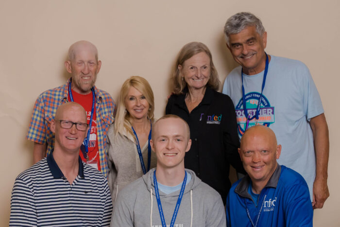 The board members stand in two rows with a neutral background.