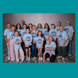 There is a large group of people standing in front of a wall at an NFED Family Conference. They are all wearing their conference t-shirt.