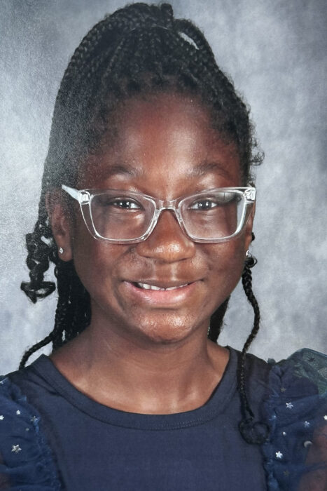 This is a head shot of Kamiah. She's wearing clear glasses and braids.