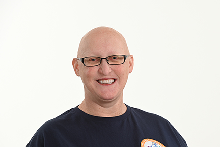 This is a headshot of Virginia who has AEC syndrome, is wearing glasses and is bald.