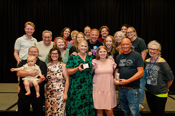 Two families are standing on a stage. 