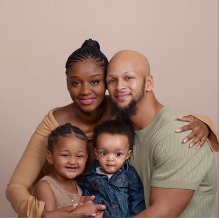 A man and woman are embracing each other and their two children.