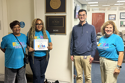 Three ELSA advocates in teal shirts pose with a staffer inside a Congressional office.